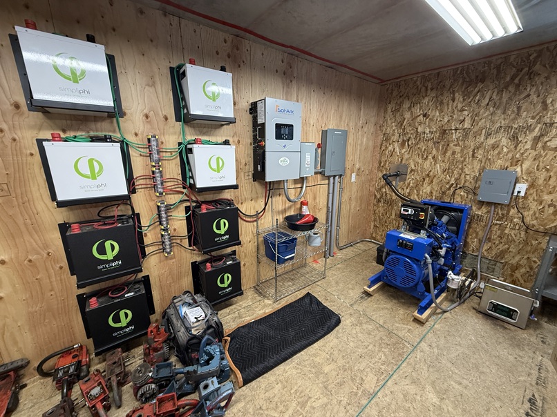 Backup generator, battery bank, and inverter system providing off-grid power for a remote Alaska cabin.