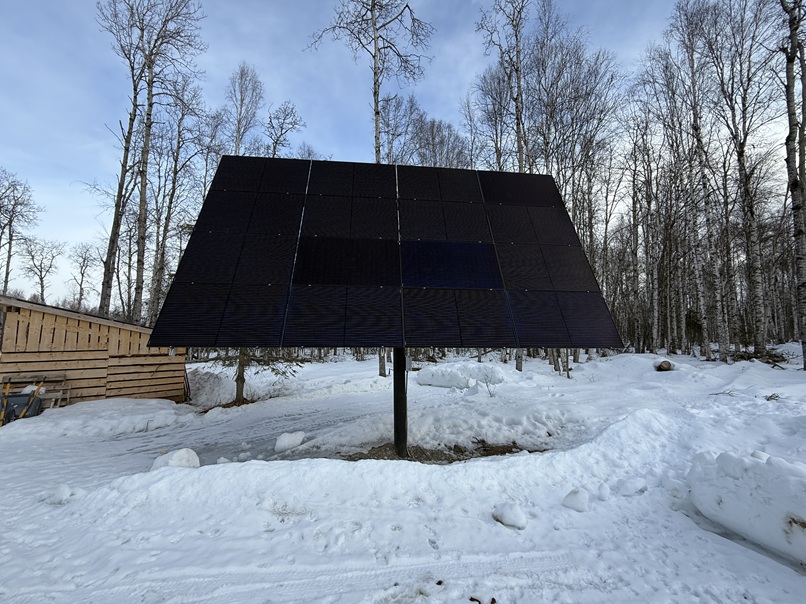 Ground-mounted solar panel system powering an off-grid cabin in remote Alaska.