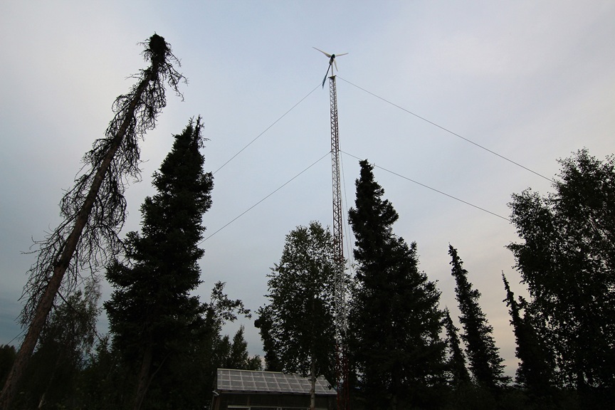 Wind turbine and solar power system supporting off-grid living at a remote Alaska property.